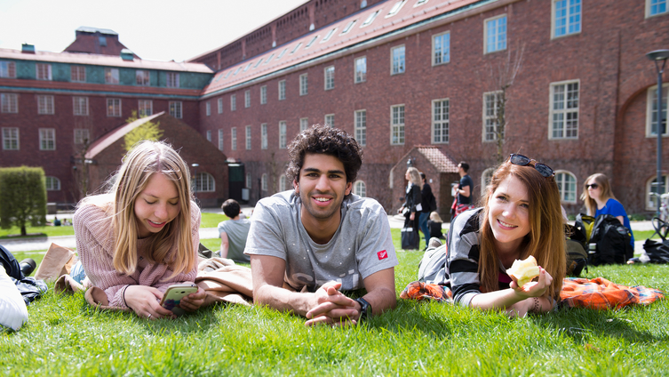 Tre studenter sträcker ut sig på gräset i en paus från högskolestudierna. Foto: Eva Dalin