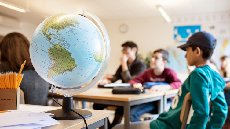 Elever i ett klassrum, jordglob i förgrunden. Foto: Scandinav