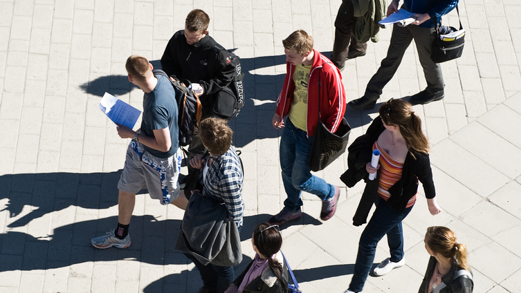 Nio ungdomar går över torget i starkt solsken på väg mot universitetet. Foto: Eva Dalin