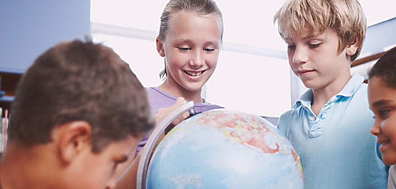 Skolelever som tittar på jordglob