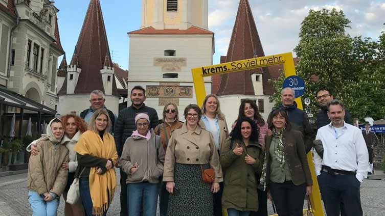 En grupp vägledare från Europa på studiebesök samlade på ett torg i Österrike.